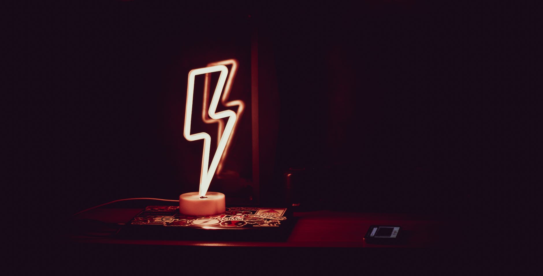 glowing neon lamp in shape of lightning in dark room